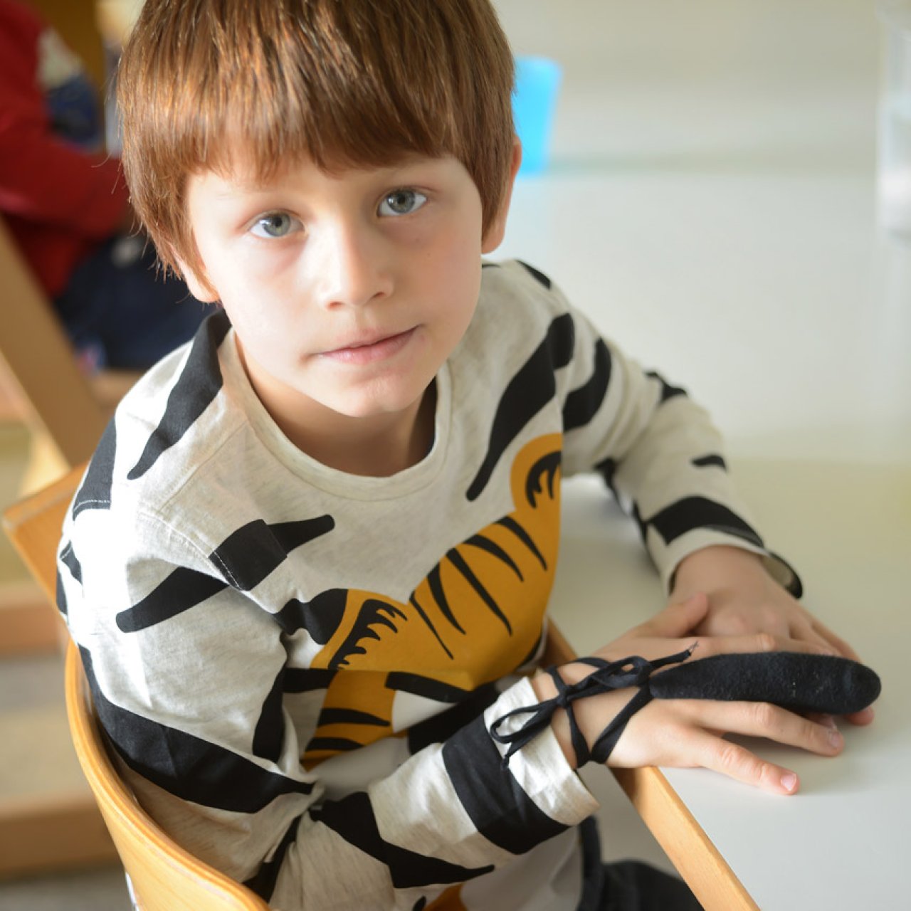 Notfallgruppe-Bild Junge sitzt am Tisch