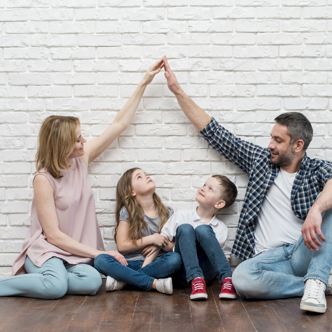 Bild II Familie sitzt am Boden, Eltern, Mädchen und Junge